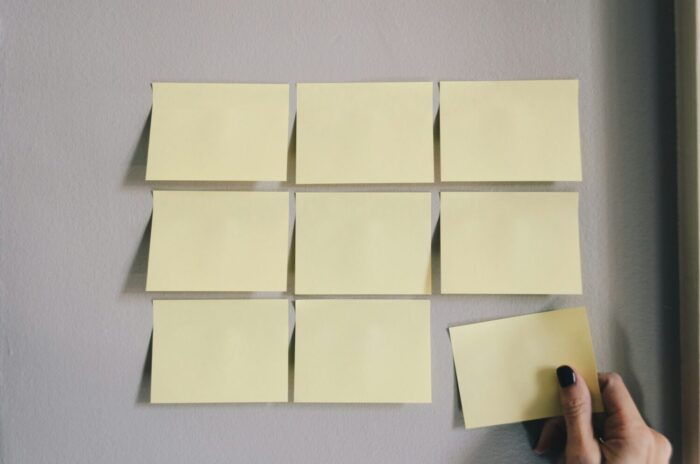 Hand adding a sticky note to an existing grid